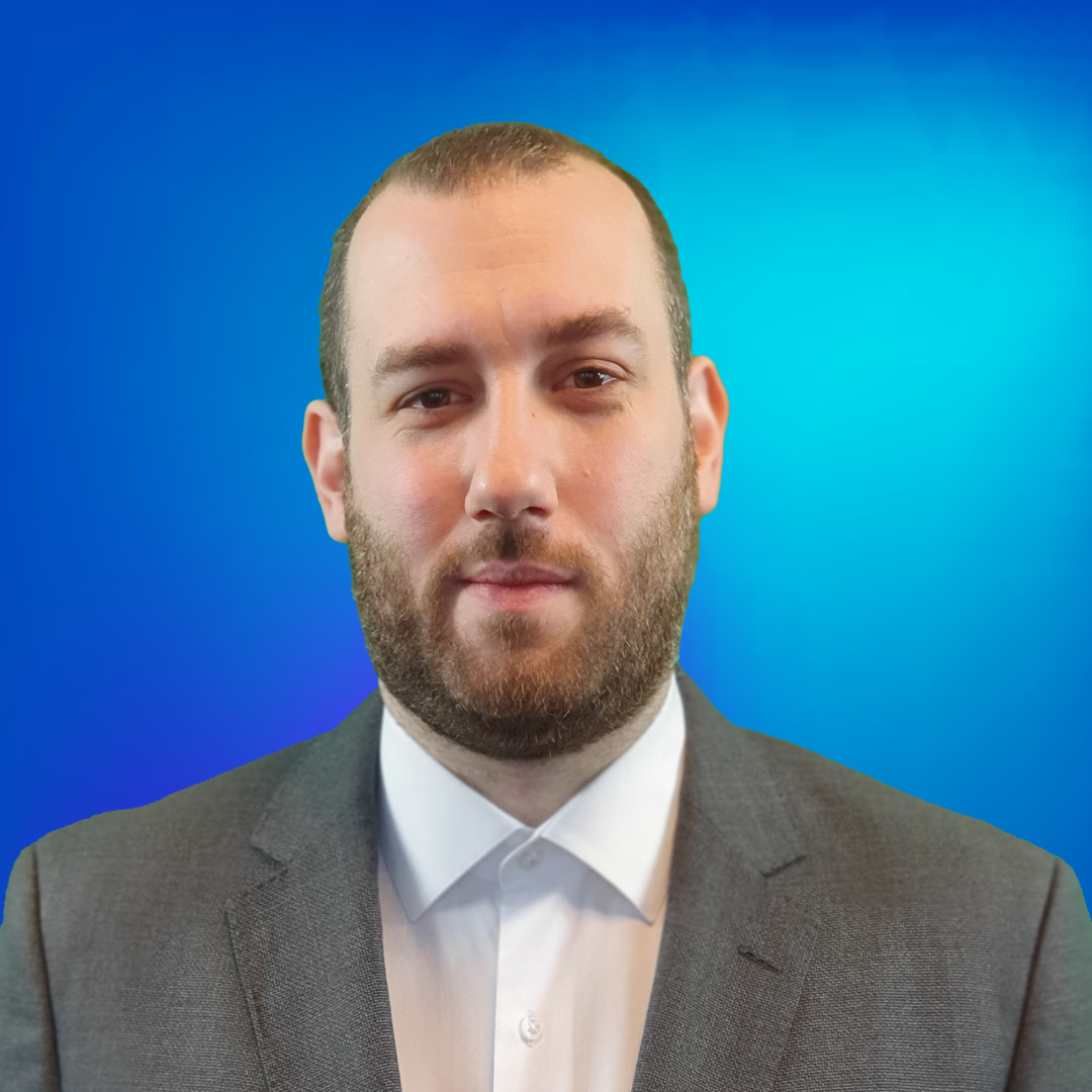 Bärtiger Mann im Anzug vor blauem Hintergrund, professionelles Bild.