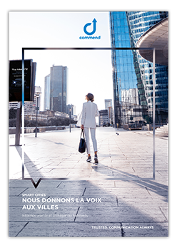 Commend: Smart Cities, Smarter Communication A woman in a white suit walks towards modern city skyscrapers, framed by an abstract graphic element. Commend logo and "Smart Cities" text are visible.