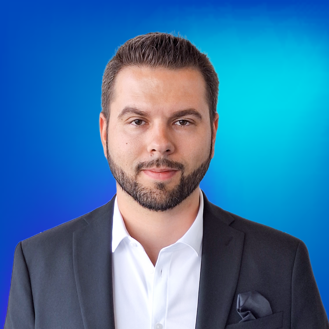 Porträt eines lächelnden, professionellen Mannes im Anzug vor blauem Hintergrund, repräsentiert Sprechanlagen.