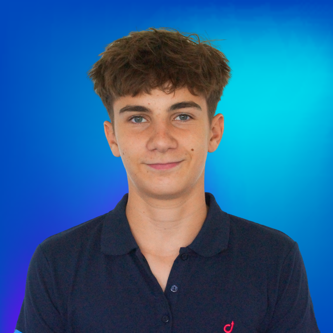 Porträt eines lächelnden jungen Mannes mit hellbraunem Haar und blauen Augen, in einem dunkelblauen Poloshirt.