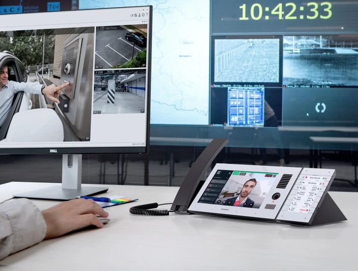 Leitstelle: Moderne Sprechanlage & Sicherheit Operator an einem Steuerpult verwaltet ein Sicherheitssystem mit Live-Feeds von einer Sprechanlage und Parkplatzansichten.