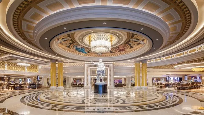 Prunkvolle Lobby mit römischer Statue Luxuriöse Lobby mit weißer Statue, Marmorboden, Kuppeldecke und großem Kronleuchter.