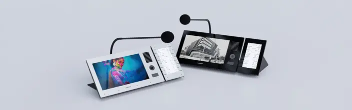White and black desktop intercoms with screens and mics on grey background.