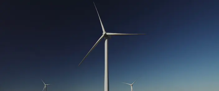 Windräder am blauen Himmel Ein großes Windrad mit zwei kleineren in der Ferne vor einem blauen Himmel.