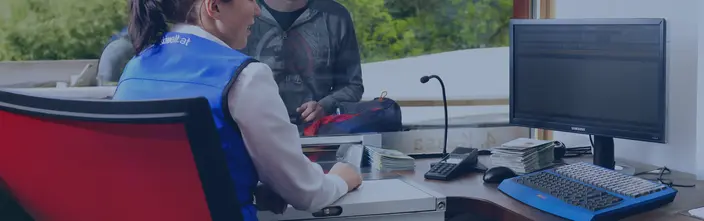 Kundenservice mit Sprechanlage Kundentheke mit Mitarbeiterin und Kunde, einer Sprechanlage und Computer für den Service.