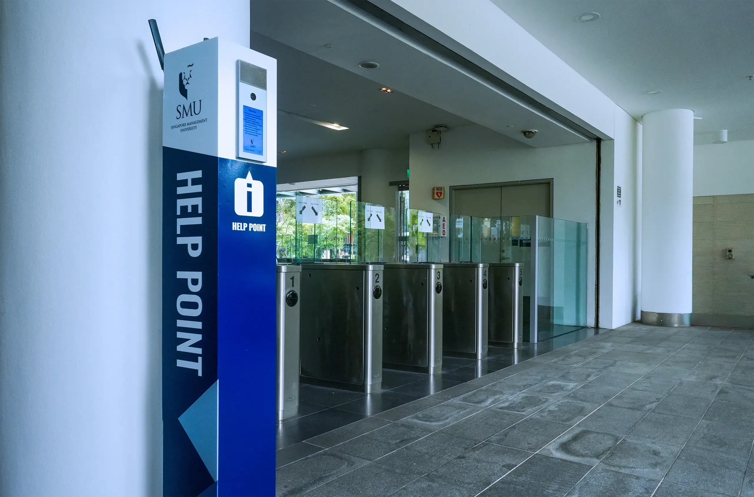 University help point next to electronic access gates providing secure entry and visitor assistance
