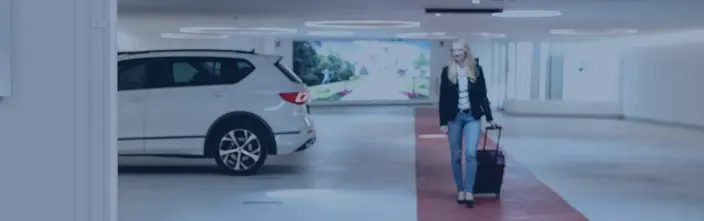 Easy Exit, Secure Car Park Woman with luggage leaving a modern car park with a white SUV.