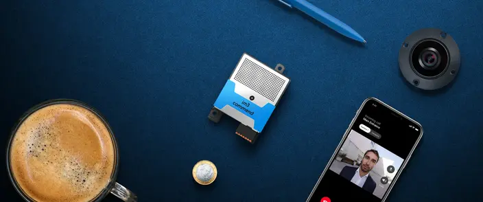 Commend im3 communication module, smartphone with video call, camera, coffee, pen on blue.
